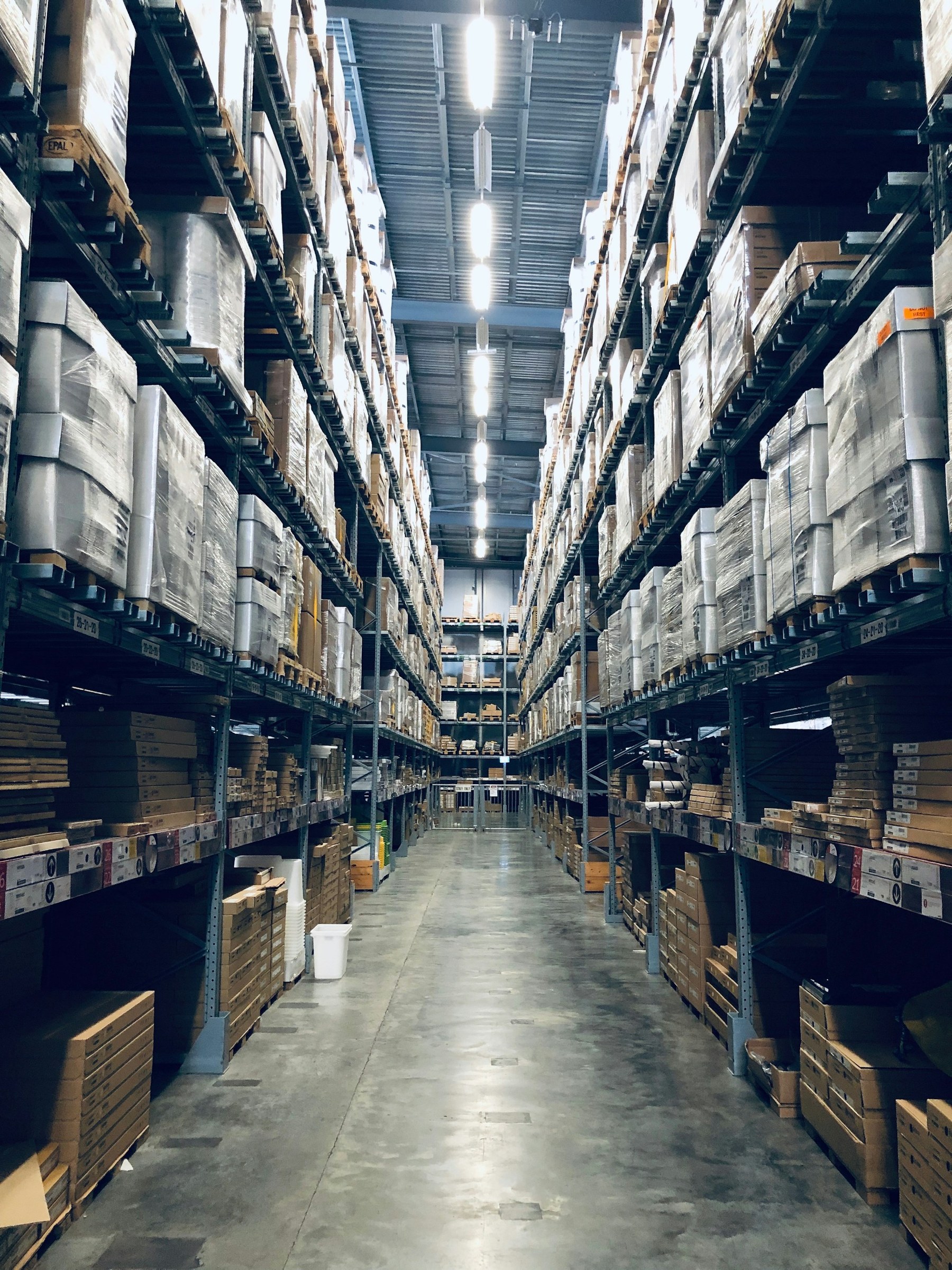 Warehouse aisle lined with tall racks of palletized goods